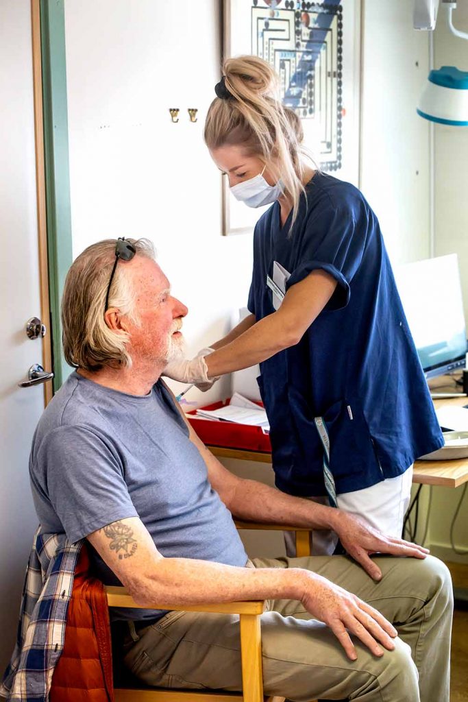 Nyinflyttade Kaxåsbon Roland Ahlström beskriver Offerdals hälsocentral som en lyx. Här får han en vaccindos av Linda Emilsson.
