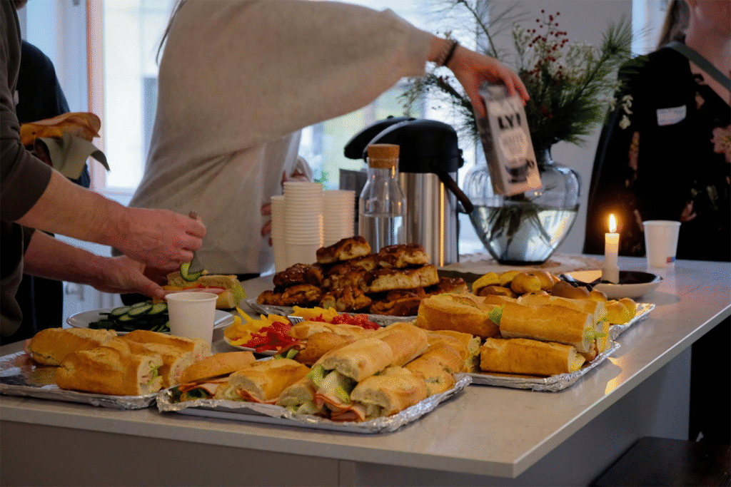 Deltagare på nätverksträffen tar för sig av smörgåsar, bullar och kaffe som de boende på Brofästet har förberett.